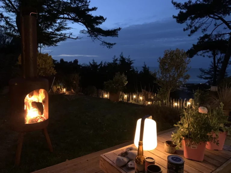 Brasero au crépuscule dans le jardin du Carré Vue Mer, avec la mer en arrière-plan